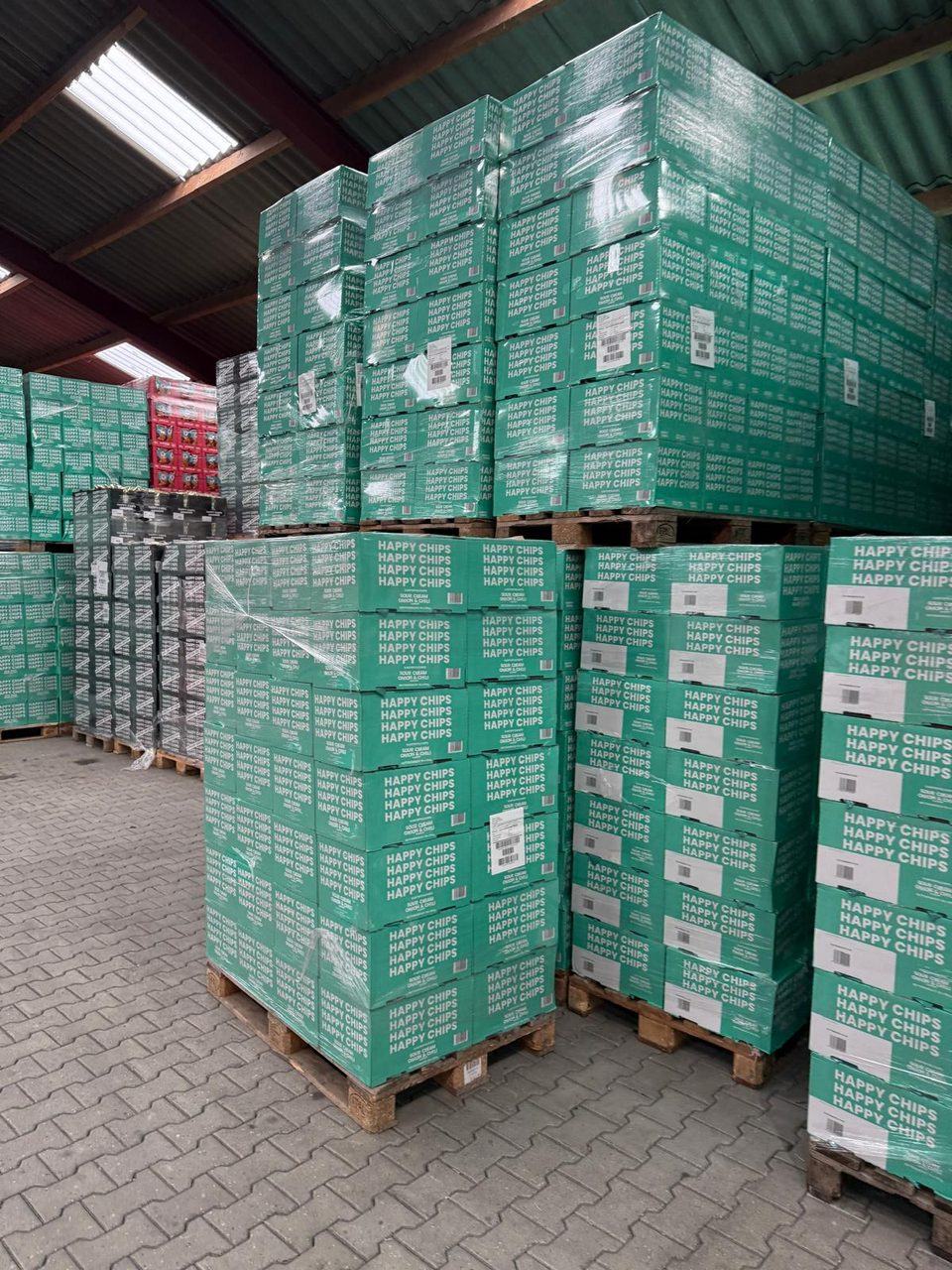 Cartoni di patatine sour cream, onion e chili impilati su pallet
