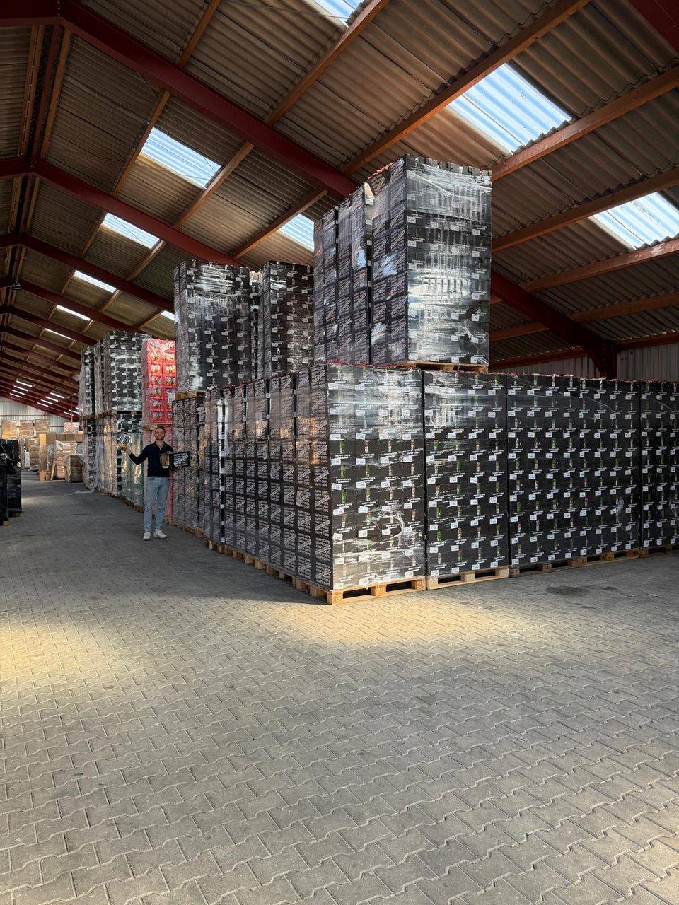 File di pallet di patatine nel magazzino, con un collaboratore accanto per dare la scala