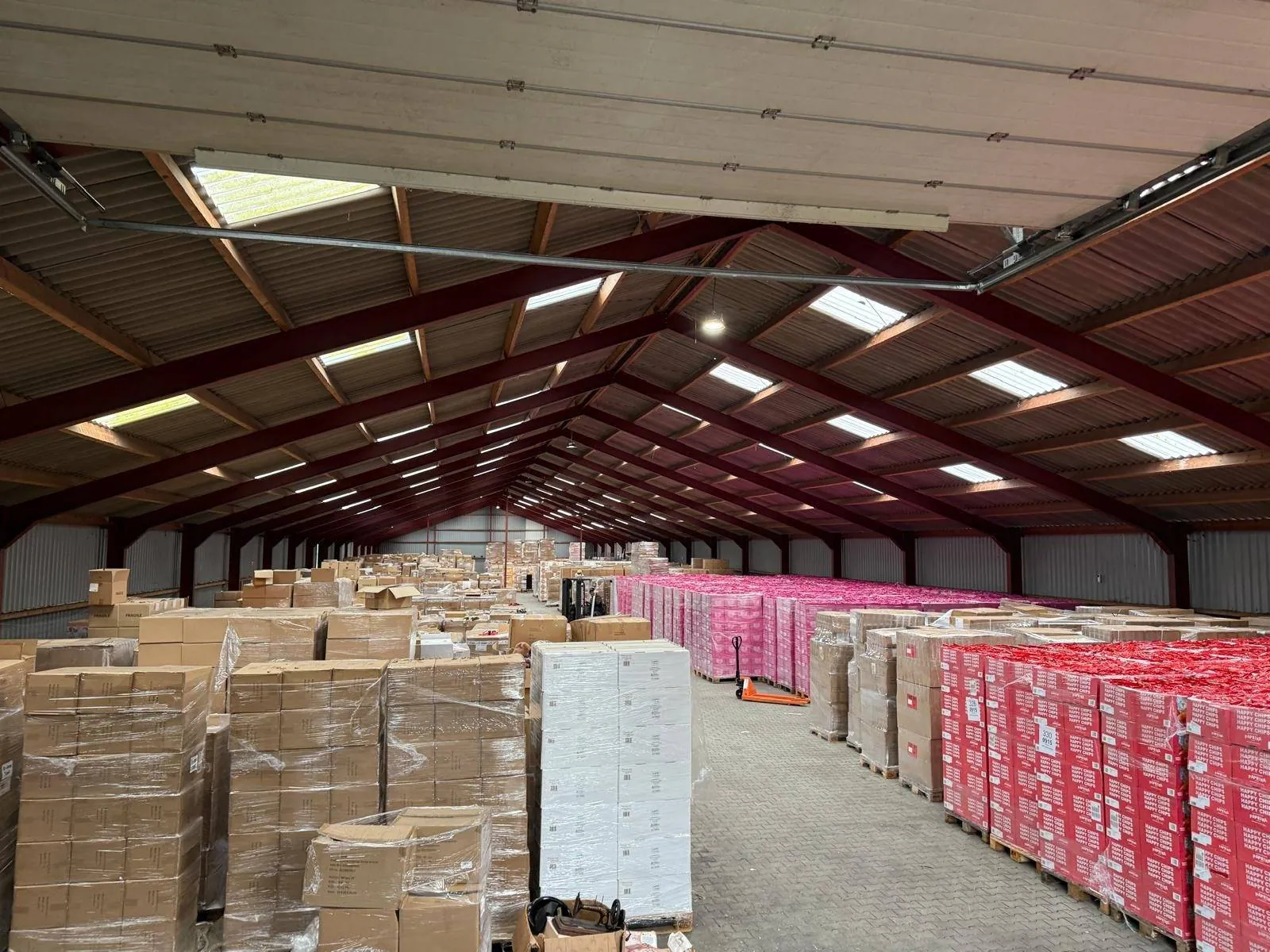 Capannone pieno di pallet di patatine dalle scorte in eccedenza, pronti per il trasporto